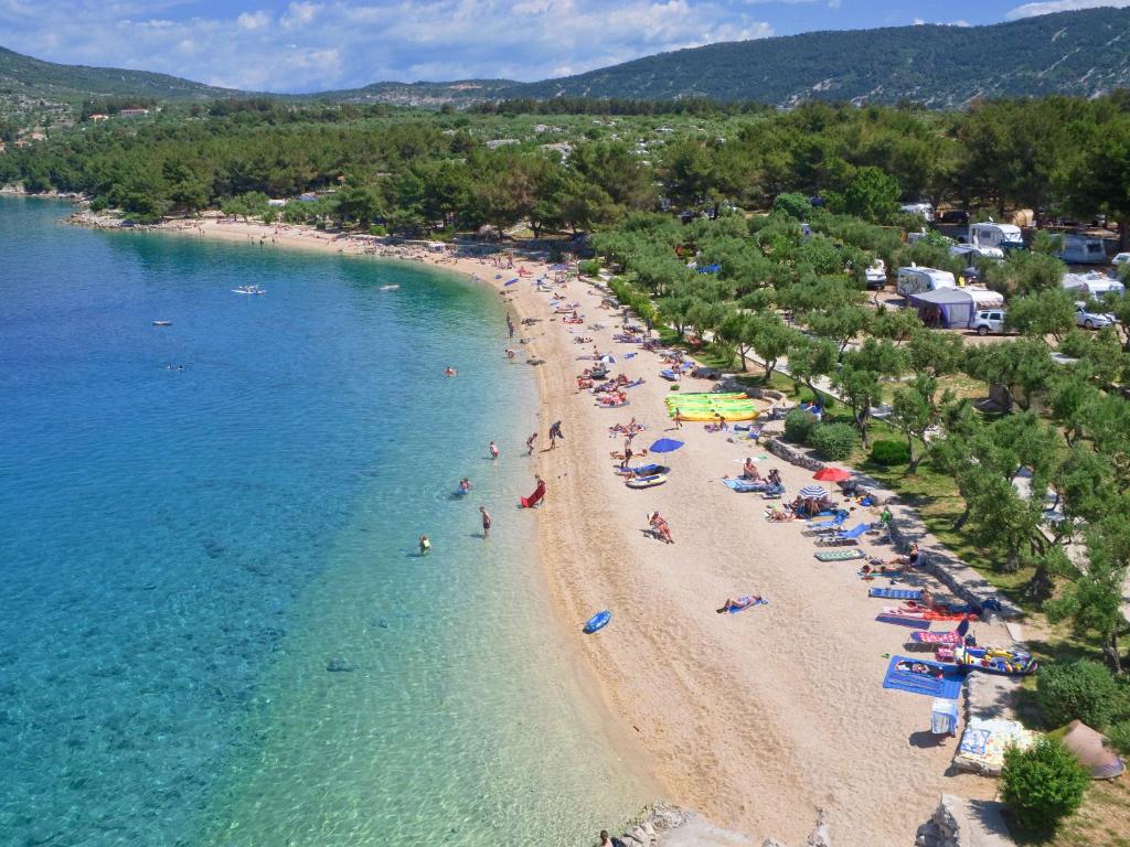 eine Aussicht über den Strand mit Menschen im Wasser in der Unterkunft Mobile Homes Camping Kovačine in Cres