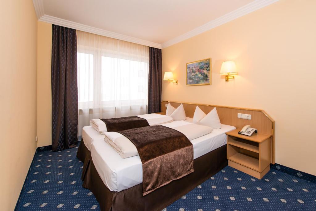 una camera d'albergo con due letti e una finestra di Hotel Royal a Monaco