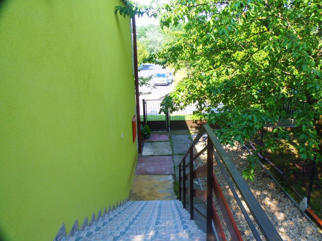 a stairway with a green wall and a fence at Hovirag apartman 2 in Hajdúszoboszló