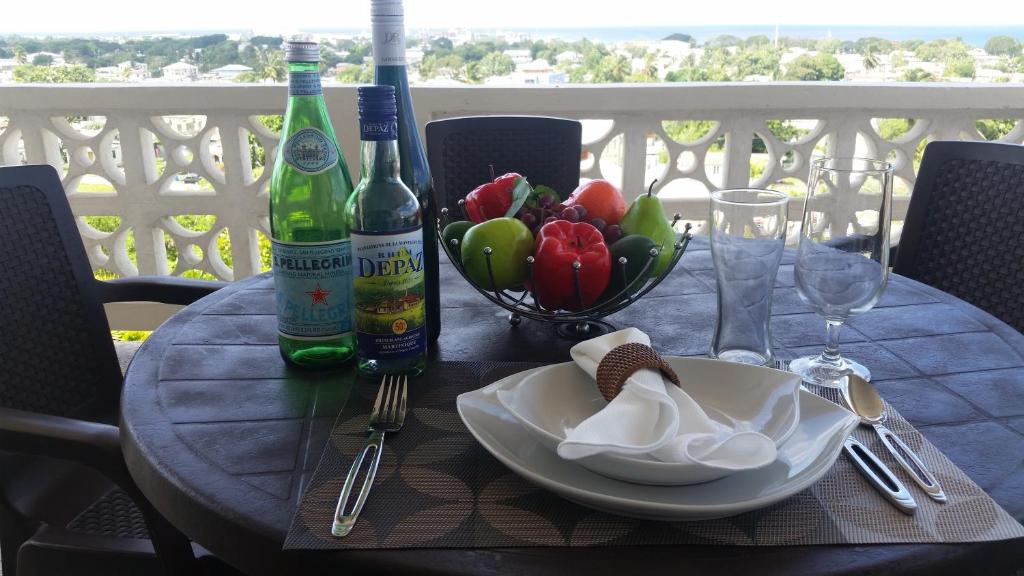 una mesa con 2 botellas de vino y un bol de fruta en A Home Away from Home en Saint Michael