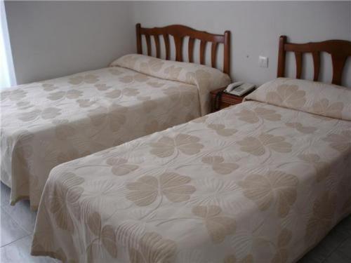 dos camas sentadas una al lado de la otra en una habitación en Hostal Excelsior en Madrid