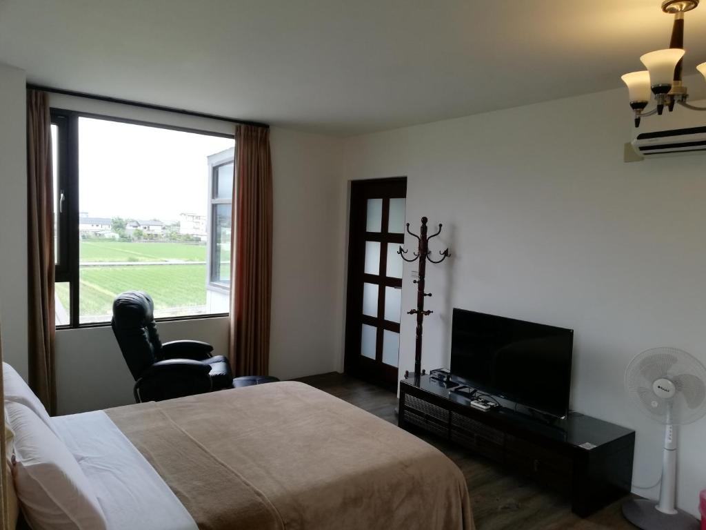 una camera da letto con un letto, una tv e una finestra di Tata House B&B a Xingjian