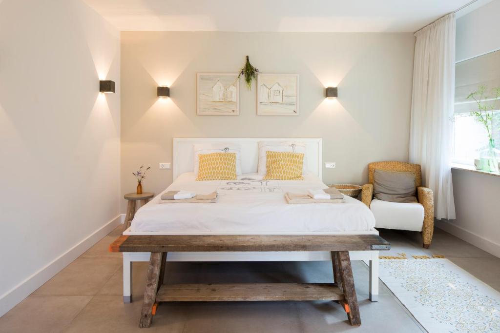 een slaapkamer met een wit bed en een tafel bij Het Ockhuis in Moergestel