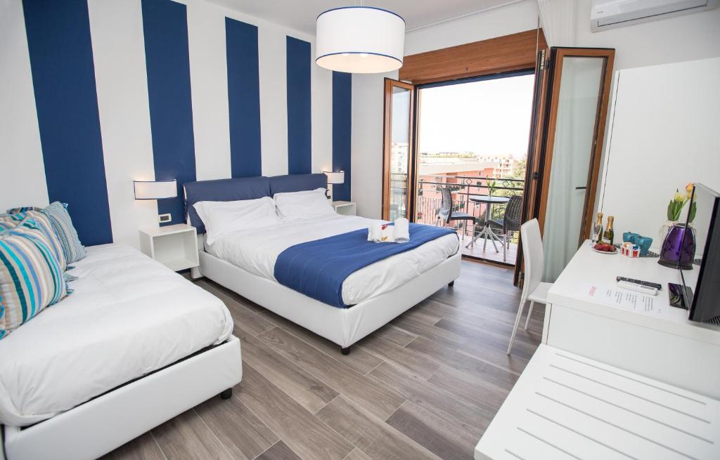 a hotel room with two beds and a balcony at Sea Room Sorrento in Sorrento