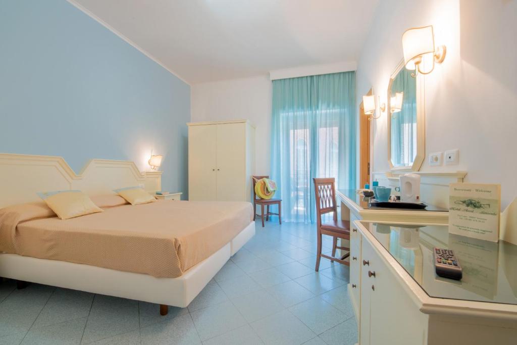1 dormitorio con cama, escritorio y cocina en Hotel Ascot Sorrento, en Sorrento