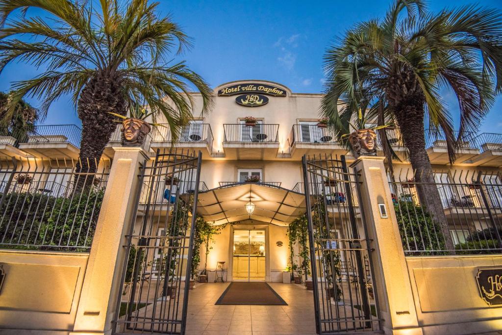 un edificio con palmeras delante en Villa Daphne en Giardini Naxos