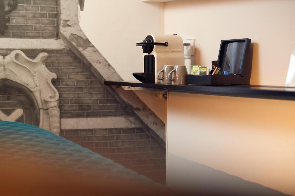 a counter with a bar with a coffee maker at Singel Hotel Amsterdam in Amsterdam