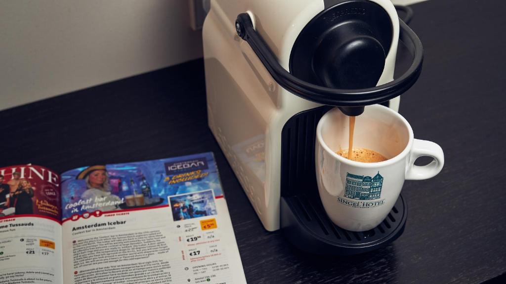 a coffee maker sitting on a counter next to a book at Singel Hotel Amsterdam in Amsterdam
