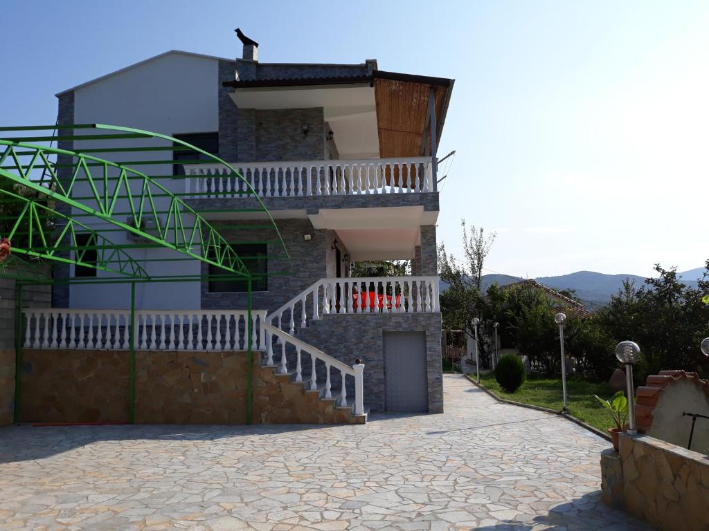 Casa con puerta blanca y balcón en Guest House Xhuljon en Berat