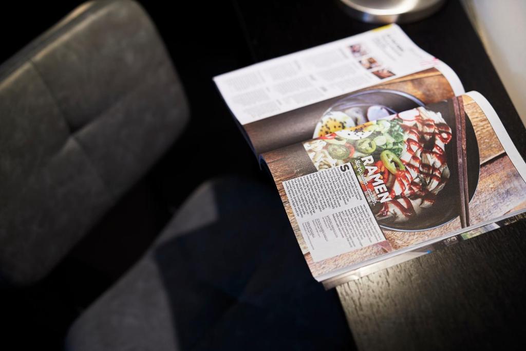 a magazine sitting on a table with a bowl of food at Singel Hotel Amsterdam in Amsterdam