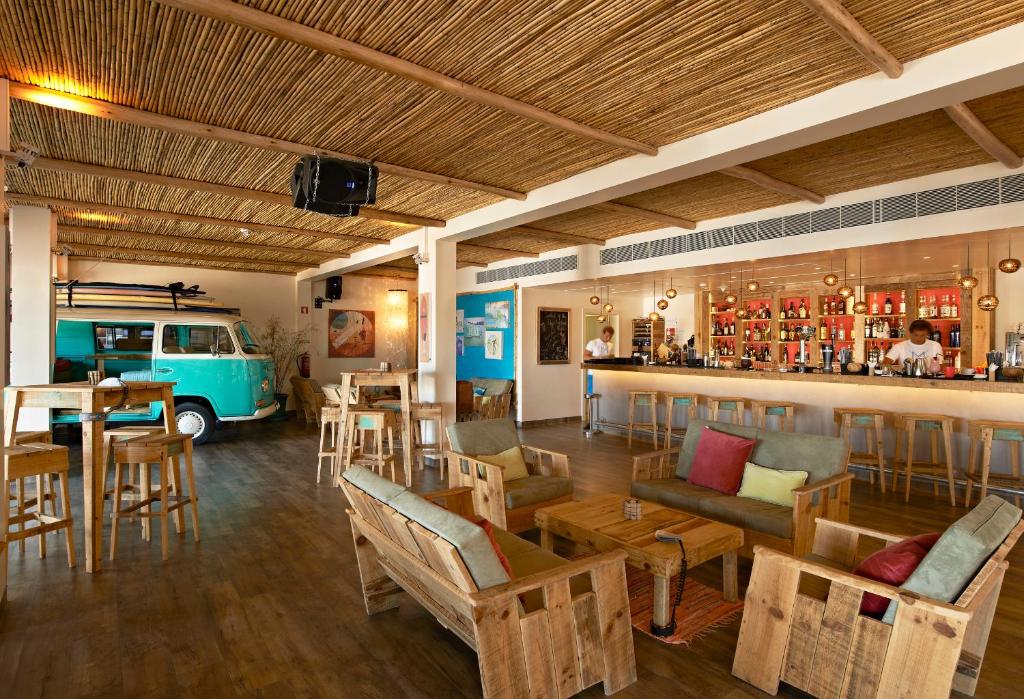 a restaurant with a bar with chairs and tables and a van at Martinhal Sagres Beach Family Resort Hotel in Sagres