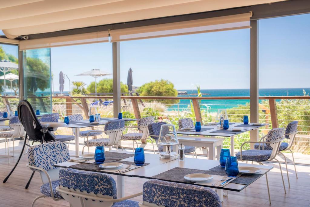 a restaurant with tables and chairs with a view of the ocean at Martinhal Sagres Beach Family Resort Hotel in Sagres