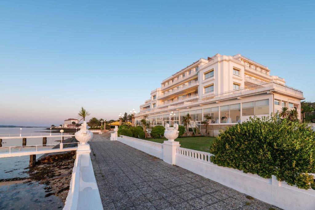 a large building with a balcony overlooking the ocean at Eurostars Gran Hotel La Toja in Isla de la Toja
