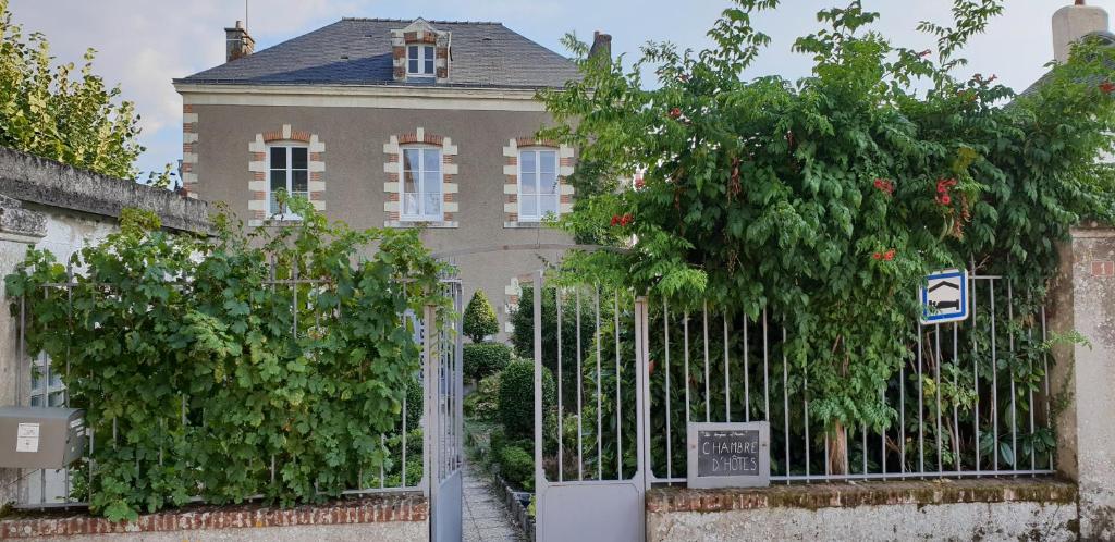 a gate in front of a house with trees at Gîte Mido in Cordemais