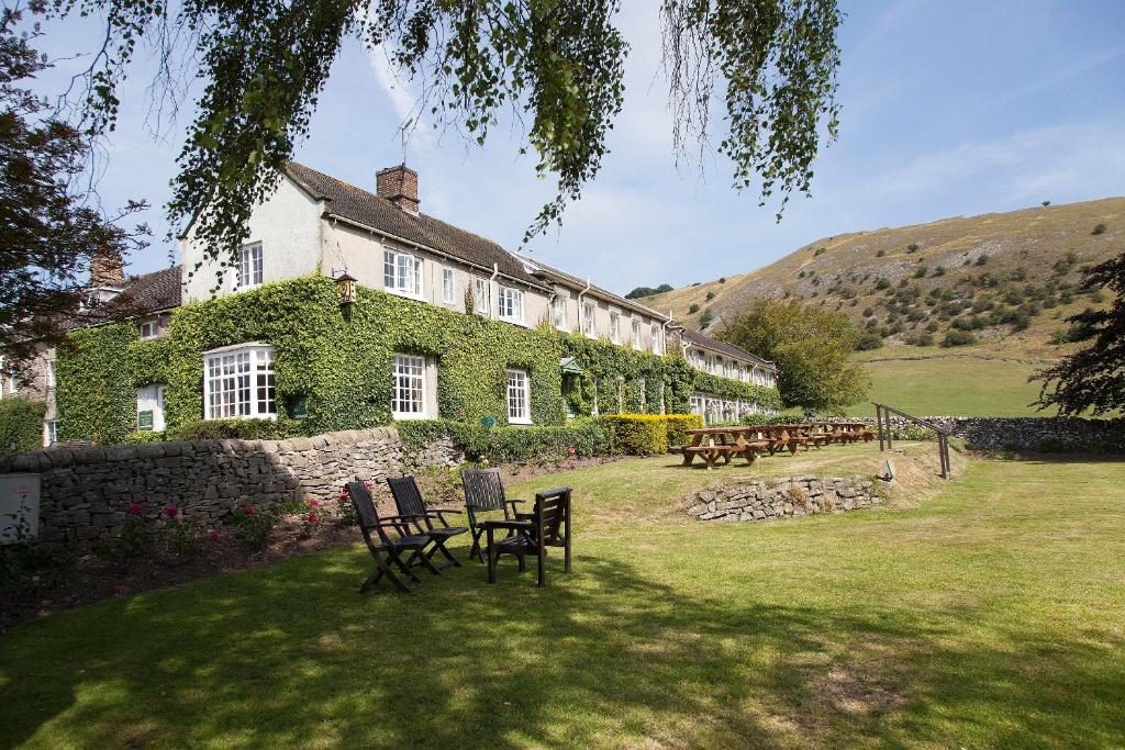 a building with chairs and tables in a yard at The Izaak Walton Country House Hotel in Ashbourne