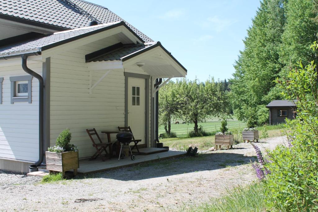 een huis met een veranda met een tafel en een grill bij Hännilän Tila in Karuna