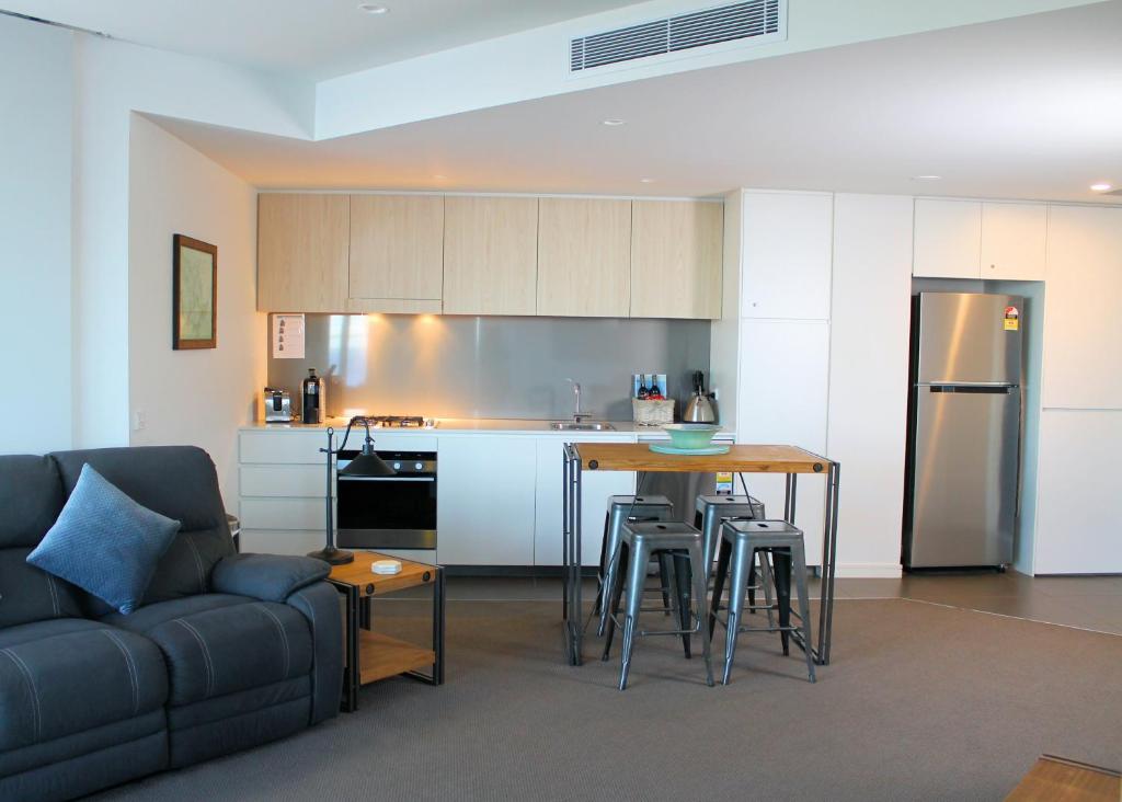 eine Küche und ein Wohnzimmer mit einem Tisch und einem Sofa in der Unterkunft Apartment On King Street in Newcastle