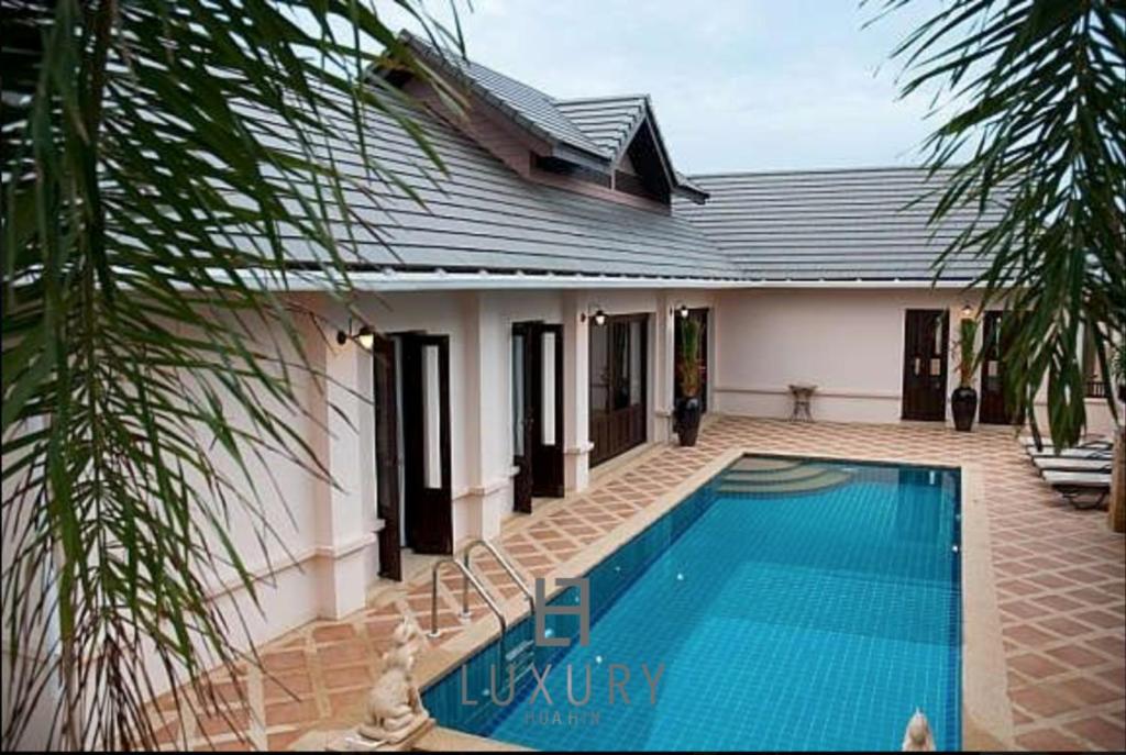 une maison avec une piscine devant dans l'établissement 4 Bedroom Private Bali Style Villa HH6, à Hua Hin