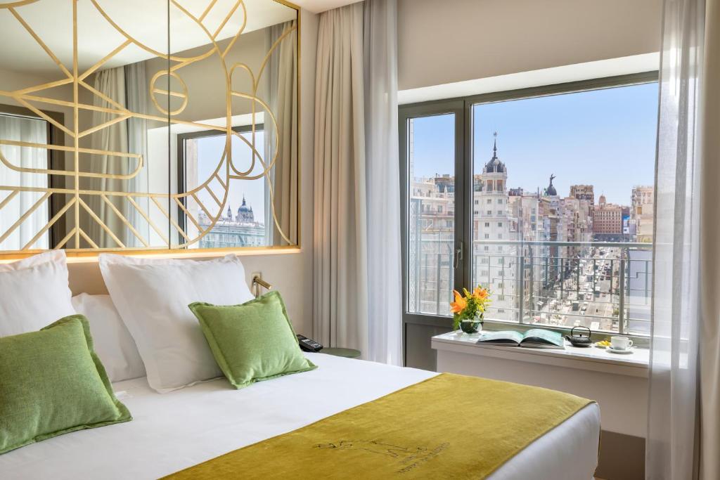 a bedroom with a bed with a view of the city at Barceló Torre de Madrid in Madrid