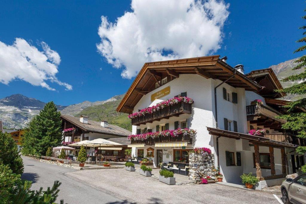 un gran edificio blanco con flores en los balcones en Hotel Alpenblick, en Pfelders