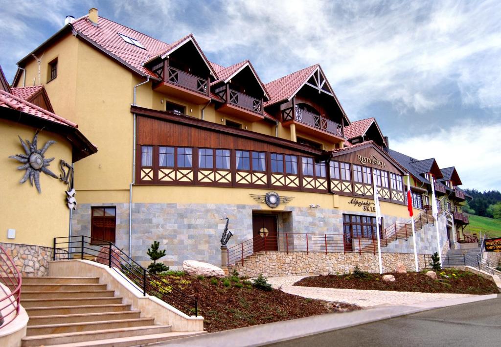 a large building with stairs in front of it at Vital&Spa Resort Szarotka in Duszniki Zdrój