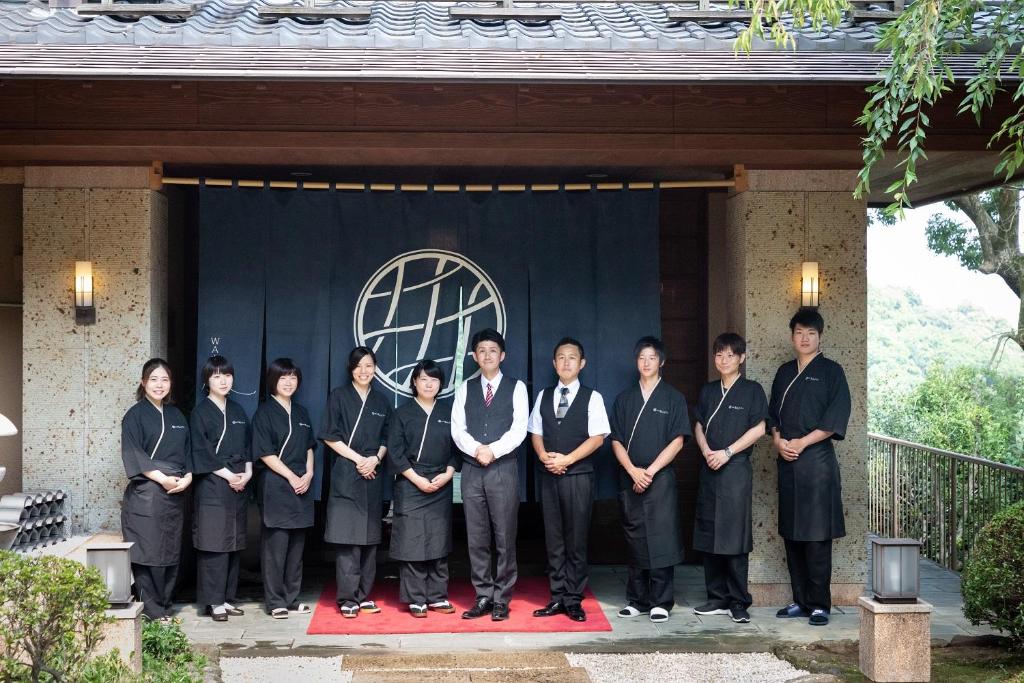 un gruppo di persone che si trovano davanti a un palco di Watei Kazekomichi ad Atami