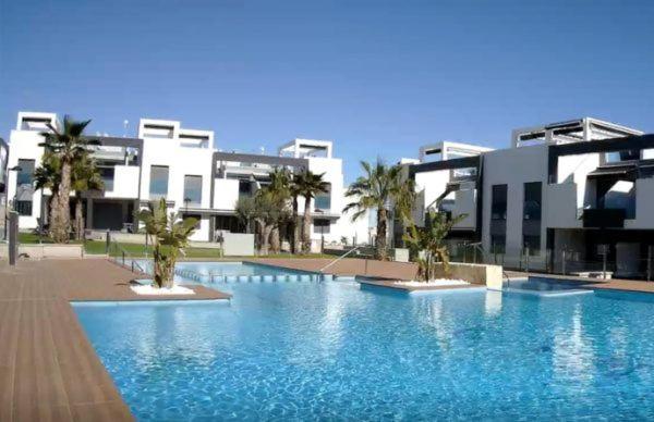 una grande piscina di fronte a un edificio di Torrevieja - Punta Prima Penthouse OASIS BEACH VII a Torrevieja