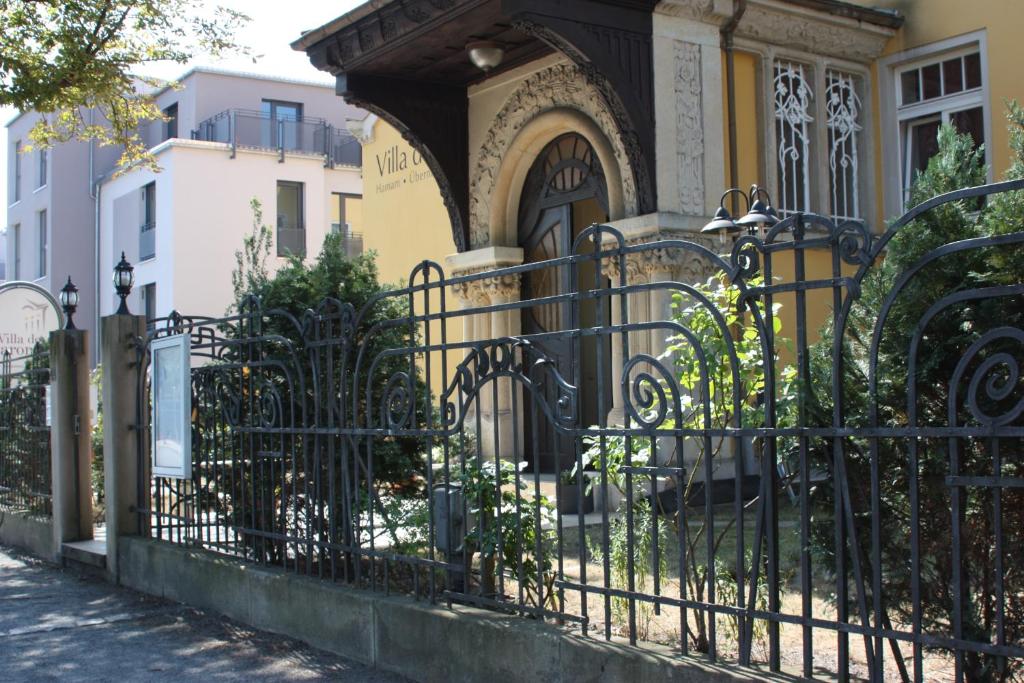 einen schwarzen schmiedeeisernen Zaun vor einem Haus in der Unterkunft Villa De Baron in Dresden