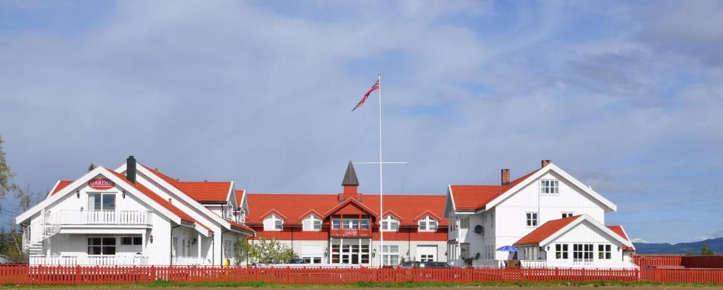 Garder Hotell og Konferansesenter في غاردرموان: بيت ابيض كبير بسقف احمر
