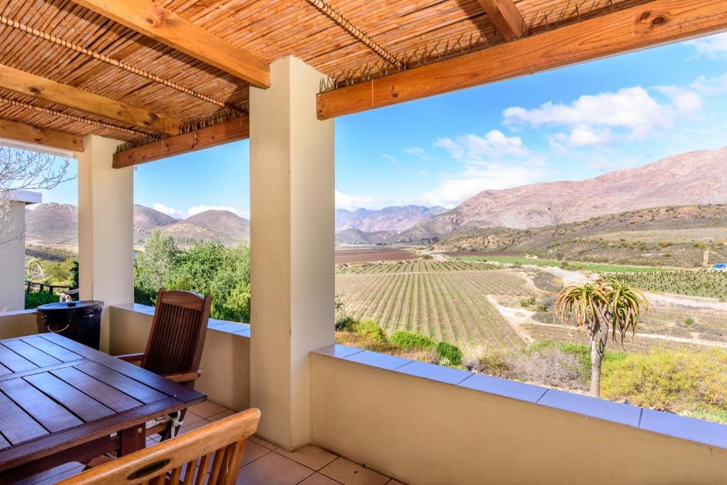 a view from the balcony of a house with a table and chairs at Bon Accord Farm Cottages in Montagu