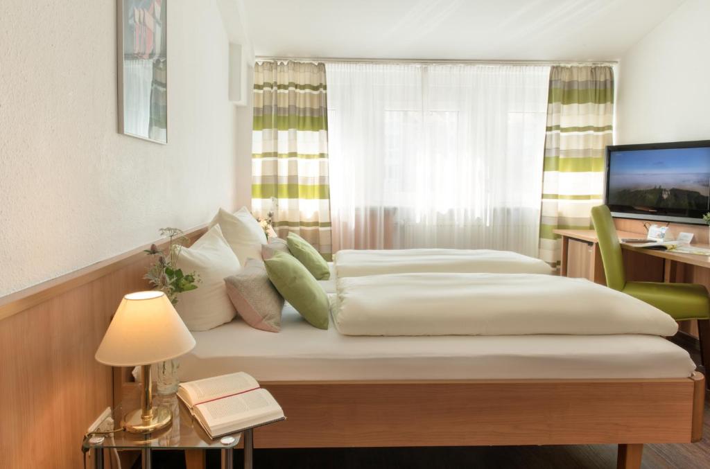 a bedroom with a large bed and a large window at Business Hotel Böblingen-Sindelfingen in Böblingen
