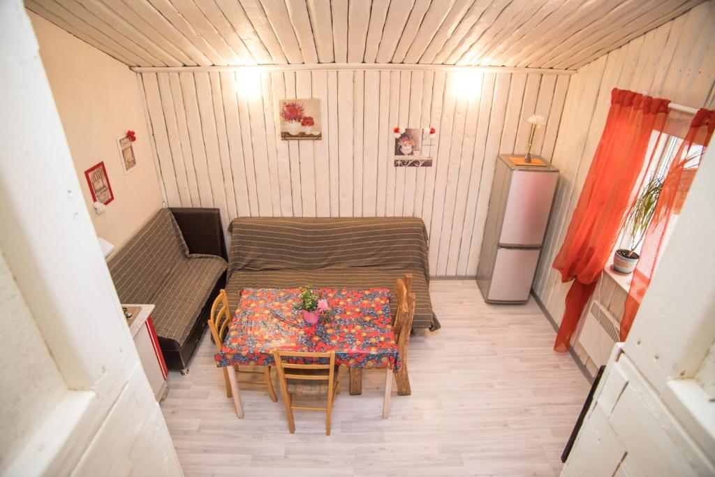 um pequeno quarto com uma mesa e cadeiras e um frigorífico em Апарт-коттедж White Rose-mini с зоной барбекю Выборг на природе em Vyborg