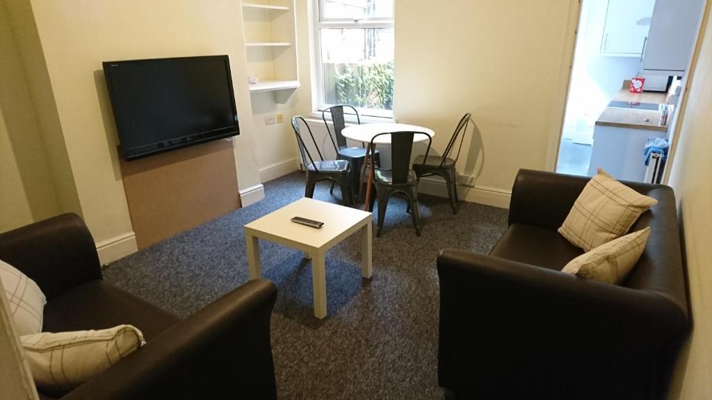 een woonkamer met banken en een tafel en een televisie bij Johnson Road Near Erdington Station in Birmingham