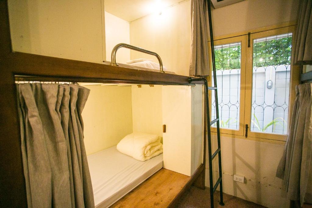 a bunk bed in a small room with a window at Barn1920s Hostel in Vientiane