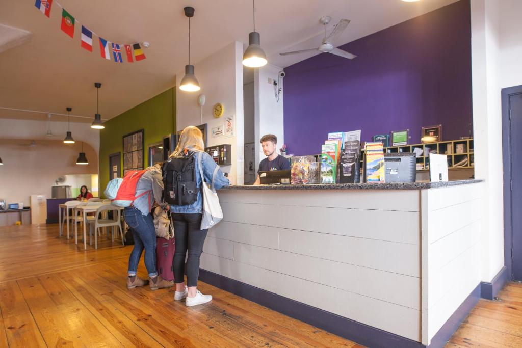 dos personas parados en el mostrador de un restaurante en Ashfield Hostel, en Dublín