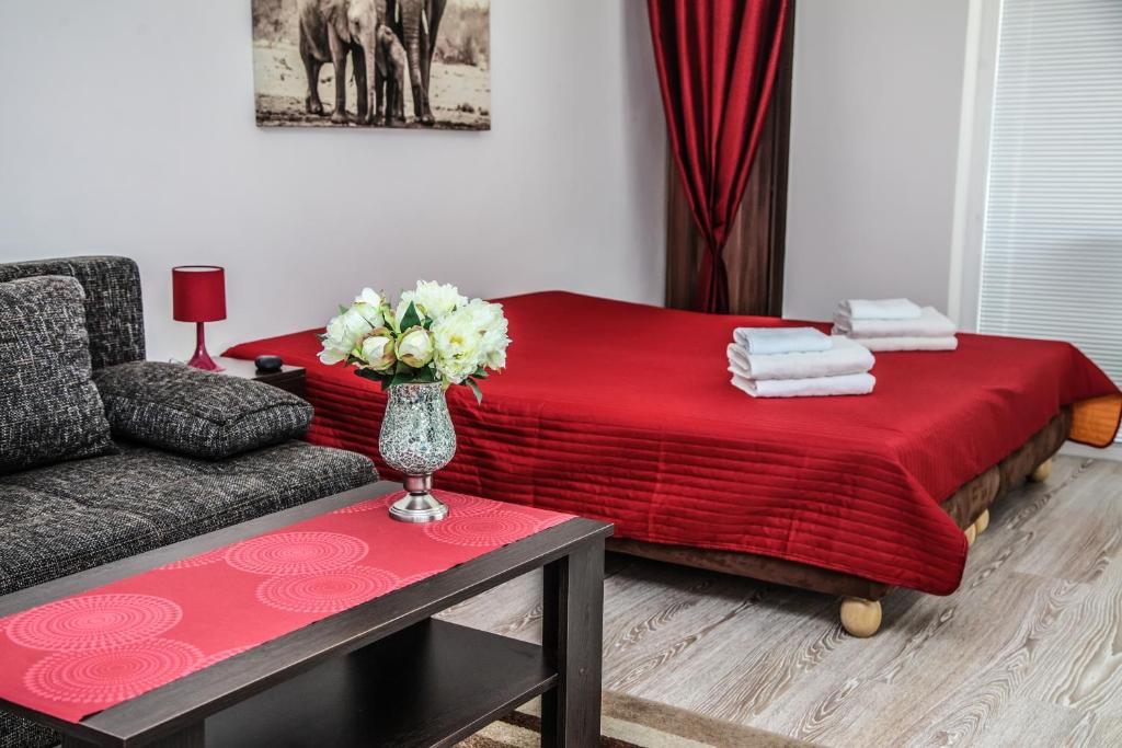uma sala de estar com um sofá e um cobertor vermelho em Apartmány RELAX Podhájska em Podhájska