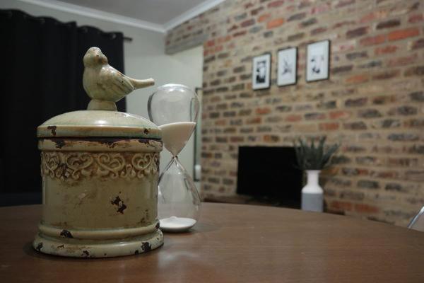 un pájaro sentado en la parte superior de un frasco en una mesa en 25 on Pretorius, en Potchefstroom