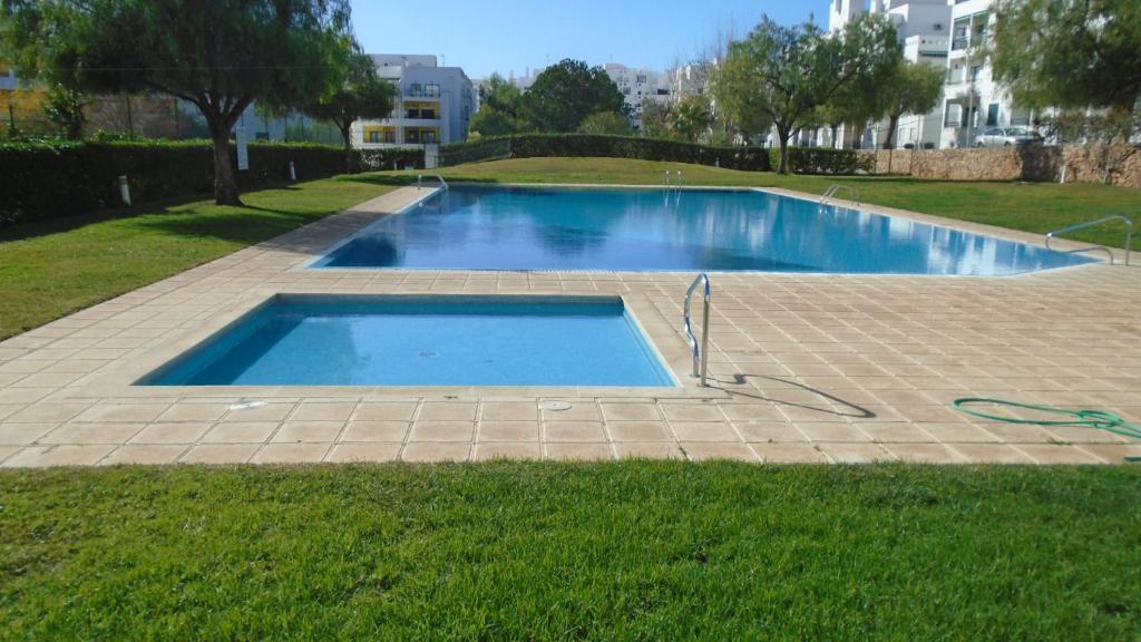 a swimming pool in the middle of a yard at Apartamento Urb. Vila Nova, Lote 5 in Armação de Pêra