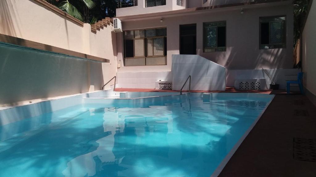 a swimming pool with blue water in a building at Ayodya Suites Nyali in Nyali