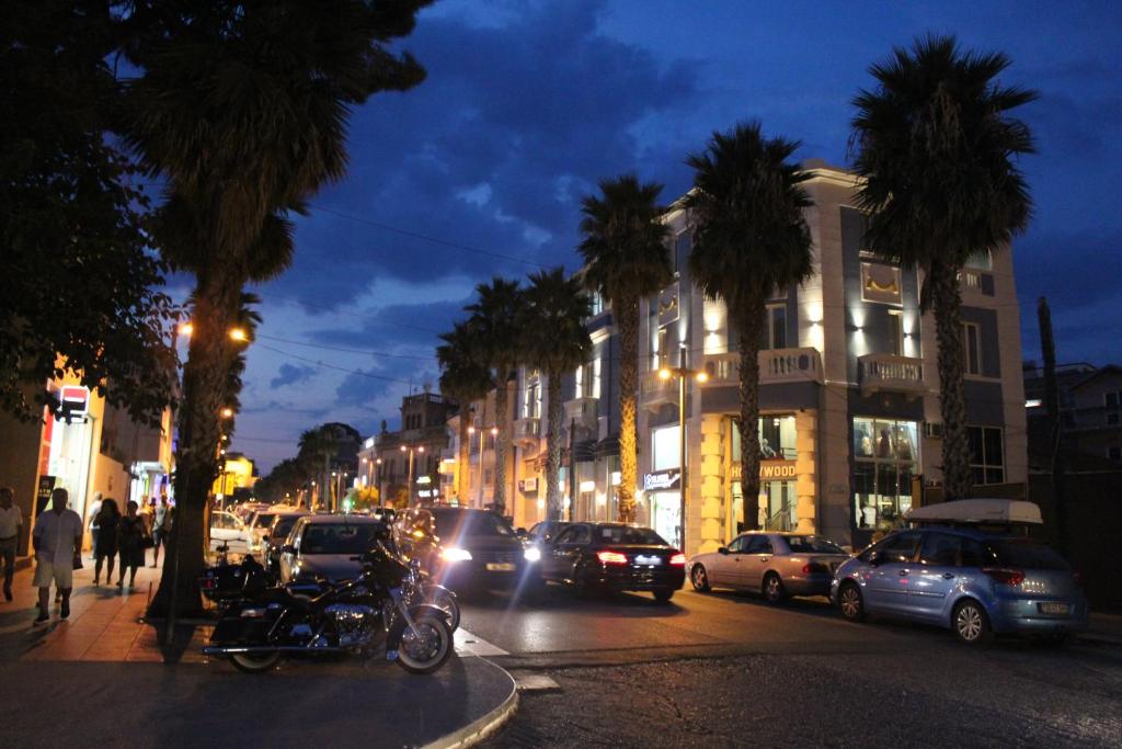 a busy city street at night with cars and palm trees at Hotel Veliera in Durrës