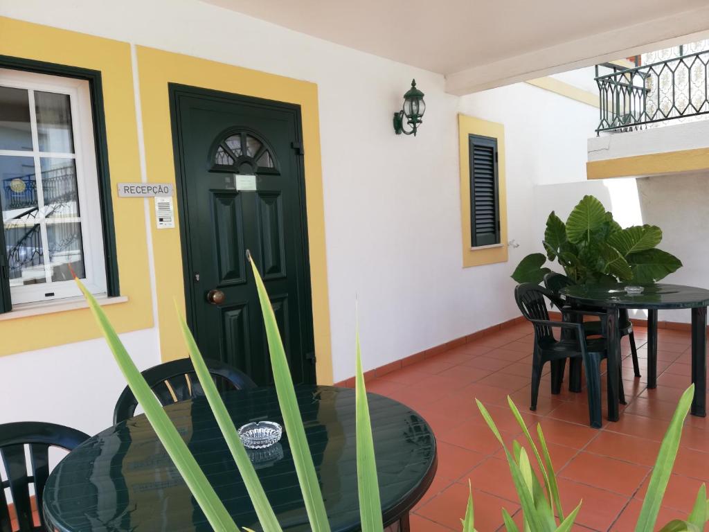 uma sala de jantar com uma porta verde e uma mesa em Residencial Idalio em Odemira