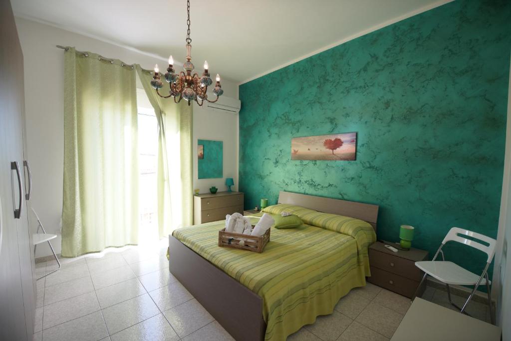 um quarto com uma cama e uma parede verde em B&B Nodo Francescano em Porto Empedocle