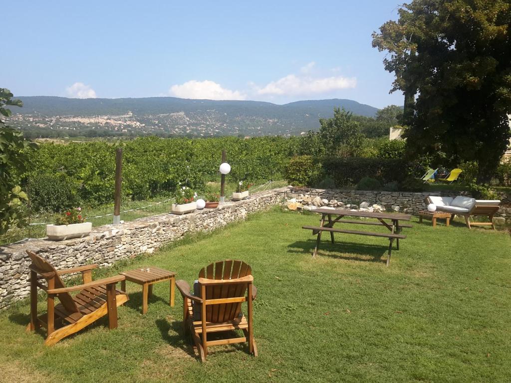 un grupo de mesas de picnic y sillas en el césped en Les Granges, en Villars