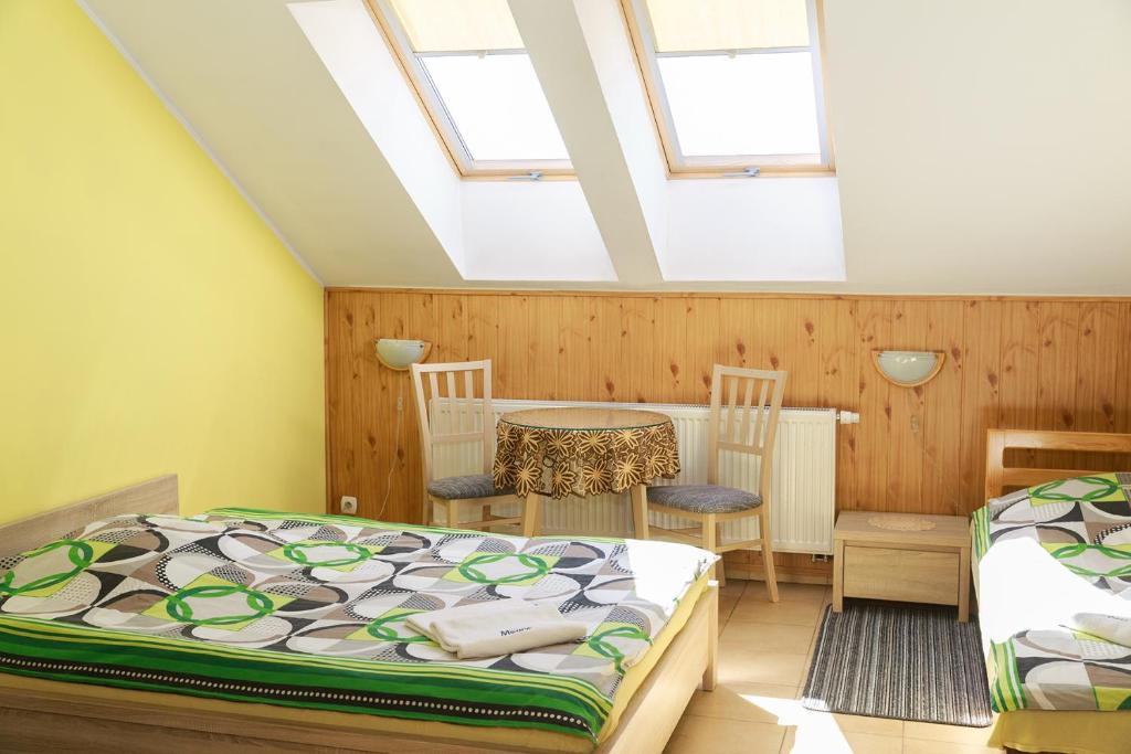 a bedroom with two beds and a table and chairs at Willa Mewa in Gdynia