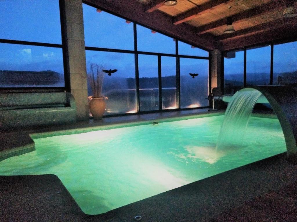 una piscina con una fuente de agua en un edificio en Casa Spa en montaña en Pontevedra