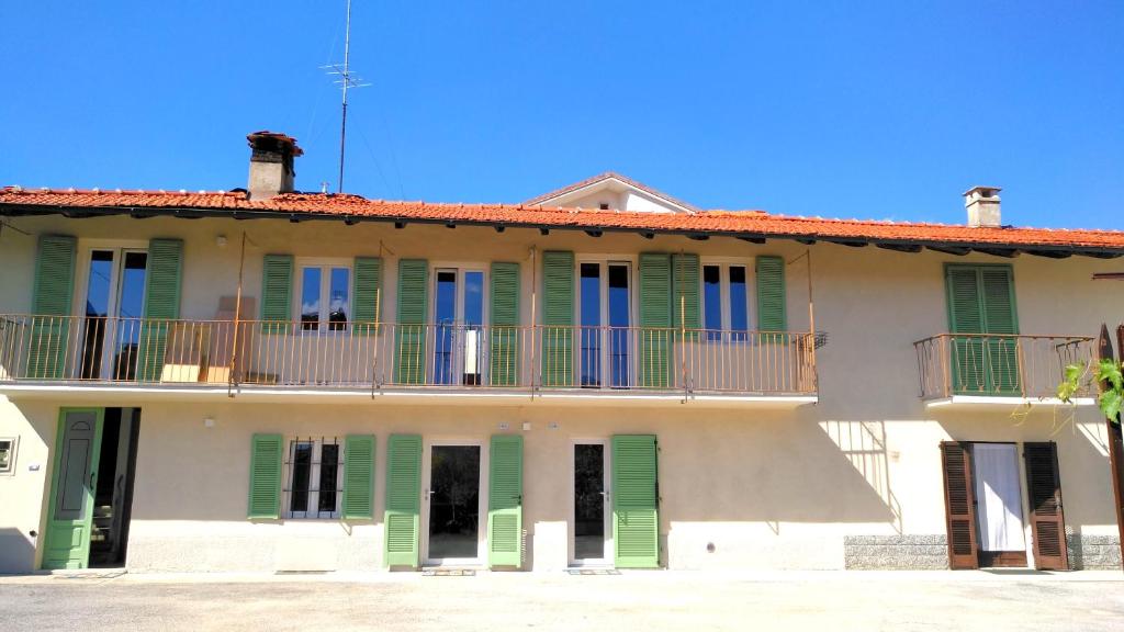 budynek z zielonymi okiennicami i balkonem w obiekcie B&B "Madama Granèt" w mieście Borgo San Dalmazzo