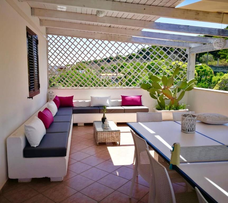 a patio with a couch and a table and a table and chairs at Casa Vacanze Fiore in Gallipoli