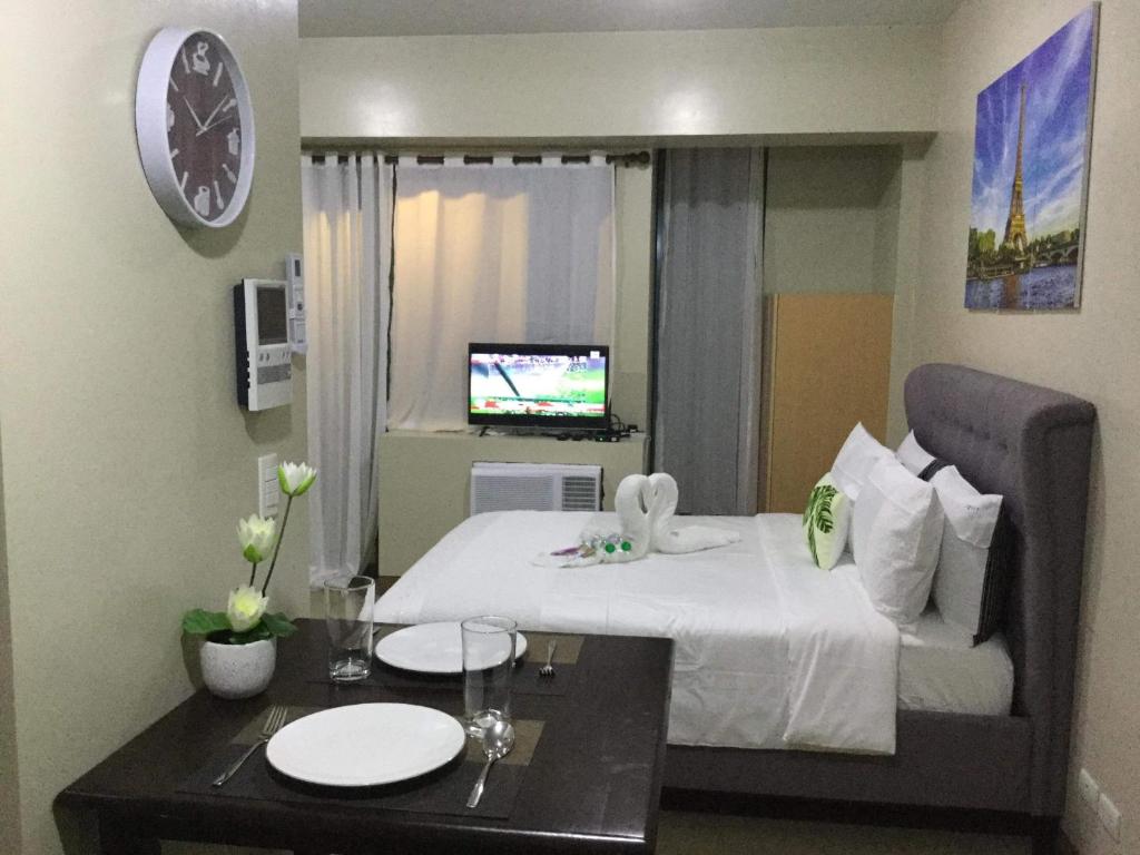 um quarto de hotel com uma cama e uma mesa com pratos em Palm Tree Villas 2 em Manilla