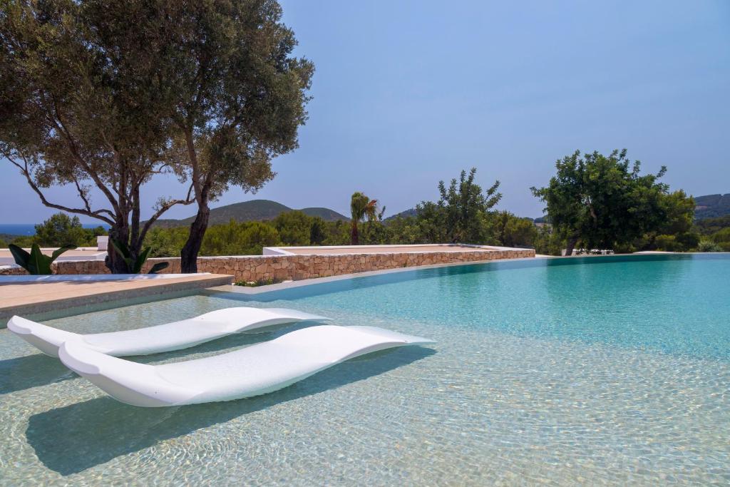 a white chair sitting next to a swimming pool at Agroturismo Can Toni Xumeu - Adults Only in Cala Llonga