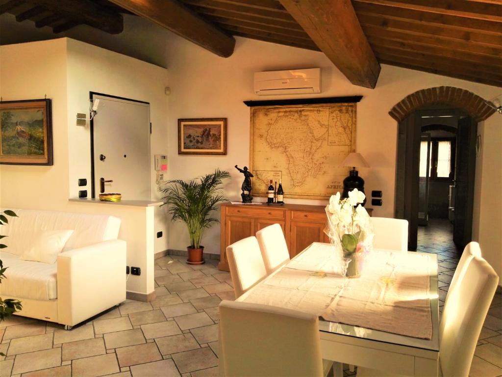 ein Esszimmer mit einem Tisch und weißen Stühlen in der Unterkunft Casa Giulia in Prato